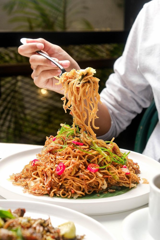 Noodles lifted from a serving plate